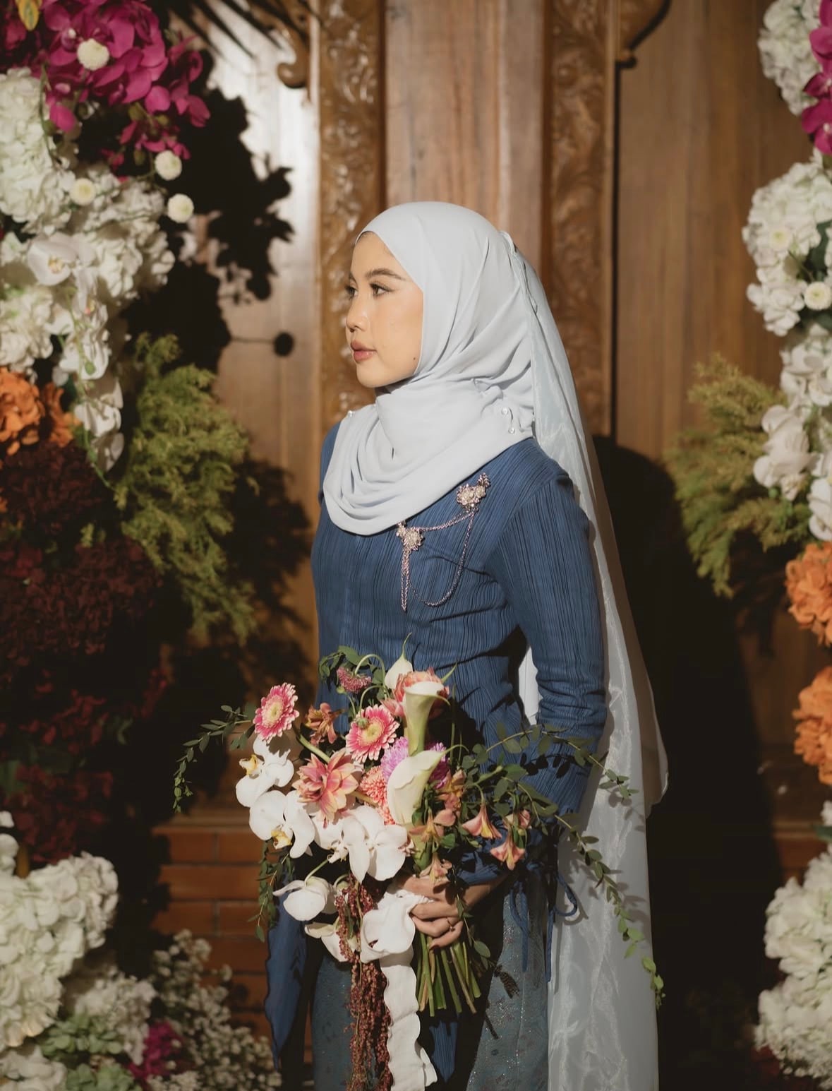 A bride outdoors in a floral-appliquéd gown and cathedral veil.
